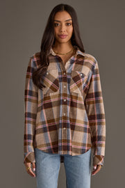 A woman stands facing forward against a plain gray background, wearing the Panache Apparel Collection’s Dark Brown, Blue & Pink Plaid Button Up and light blue jeans. She has long dark hair and wears simple jewelry.