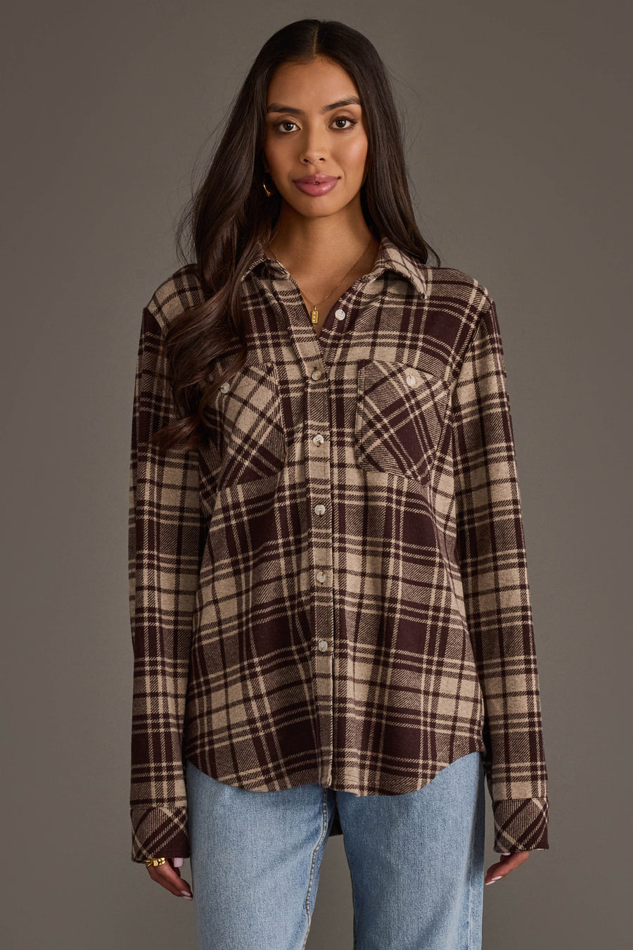 A woman stands facing forward against a plain gray background, wearing the Panache Apparel Collection Chocolate Brown & Tan Plaid Button Up paired with light blue jeans.