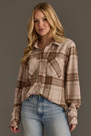 A woman with long blonde hair wears the Panache Apparel Collection Brown, Tan & Rose Plaid Button Up and light blue jeans, standing against a plain gray background and smiling softly at the camera.