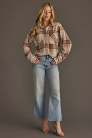 A woman stands with hands on hips against a plain gray background, wearing the Panache Apparel Collection Brown, Tan & Rose Plaid Button Up paired with light blue wide-leg jeans and beige high-heeled sandals.
