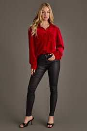 A woman with long blonde hair poses in the Red Velvet Button Up by Panache Apparel Collection, paired with black fitted pants and black open-toe heels against a plain background.
