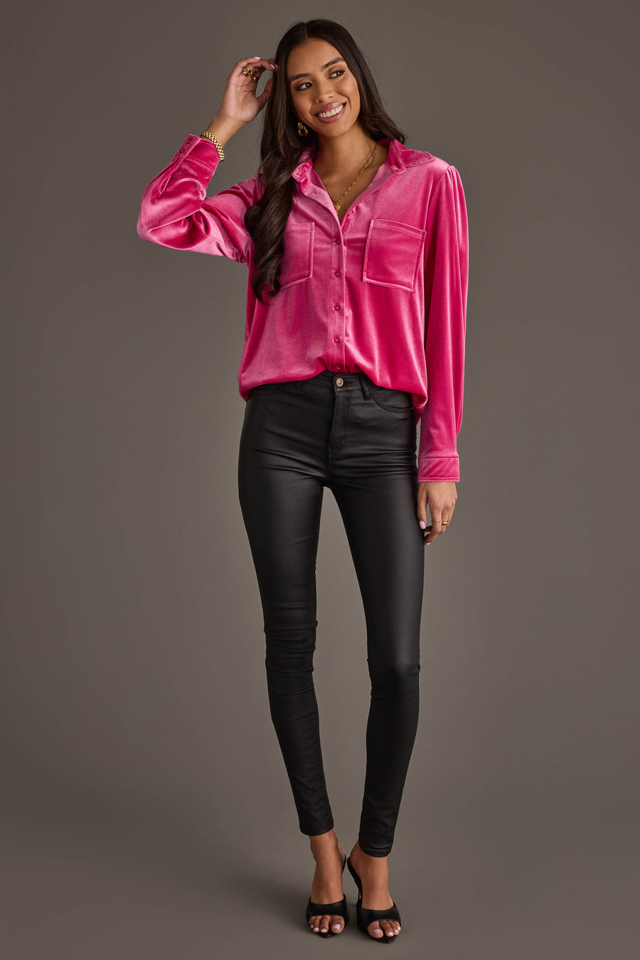 A woman stands and smiles wearing the Panache Apparel Collection Bright Pink Velvet Button Up, paired with black fitted pants and open-toe heels, posing against a plain gray background.