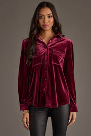 A woman in the Panache Apparel Collection Maroon Velvet Button Up and black pants stands against a plain gray background.