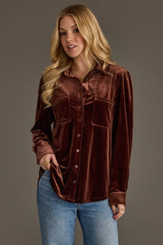 A woman with long blonde hair wears the Brown Velvet Button Up by Panache Apparel Collection and light blue jeans, standing against a gray background and looking slightly to the side.