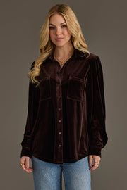 A woman with long blonde hair wears the Espresso Brown Velvet Button Up by Panache Apparel Collection and light blue jeans, standing against a plain gray background.