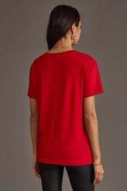 Back view of a person wearing a plain red, relaxed fit On The Naughty List Tee.