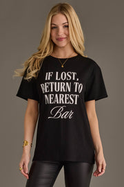 Woman wearing Panache Apparel’s black If Lost, Return To Nearest Bar western graphic tee.