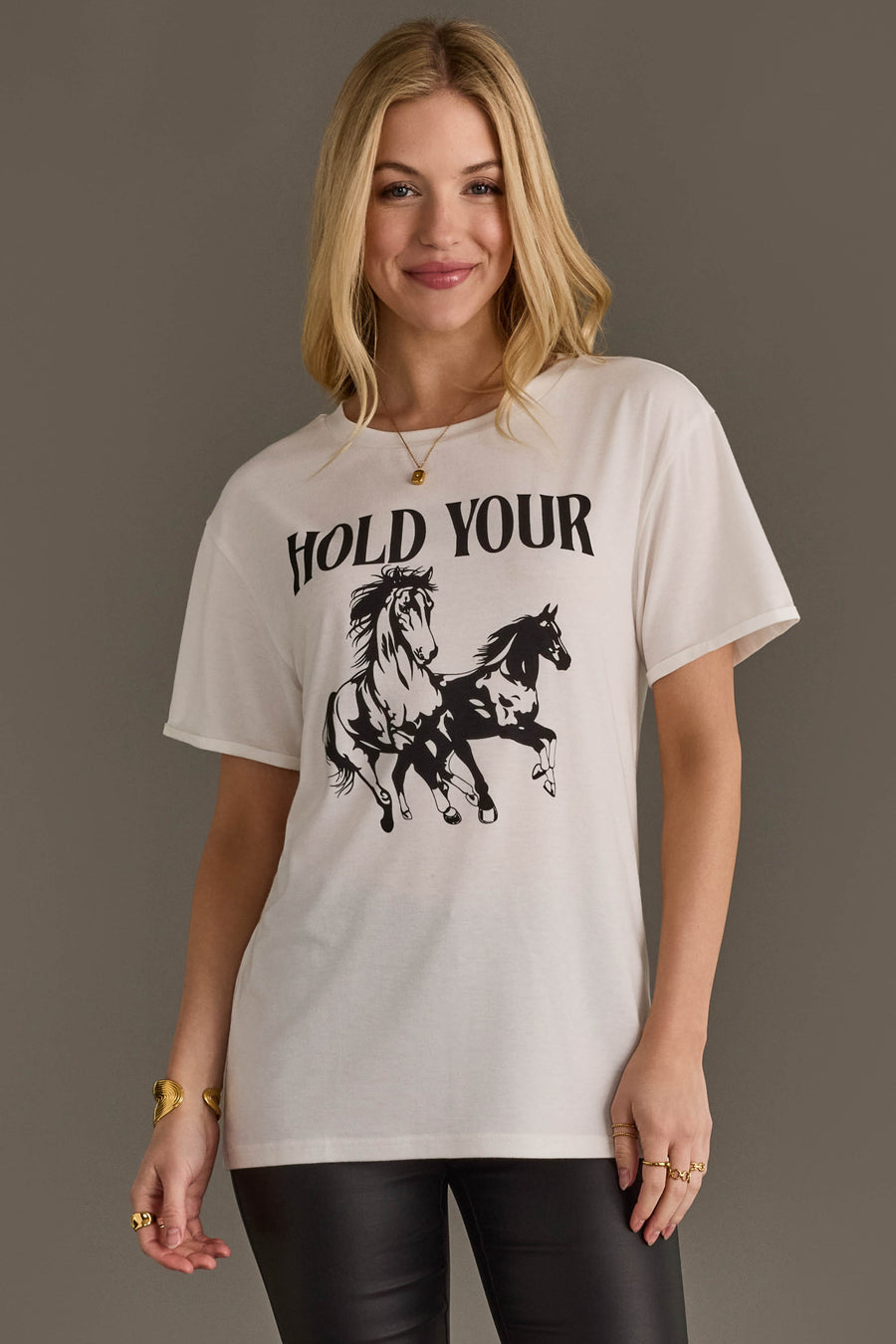 Woman wearing Panache Apparel’s white Hold Your Horses western graphic tee.