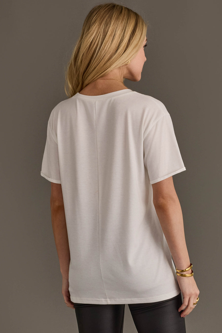Back view of woman wearing Panache Apparel’s white Hold Your Horses western graphic tee.