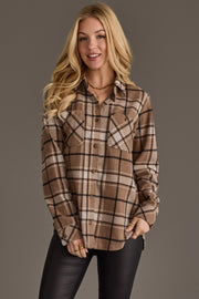 A woman with long blonde hair wears the Panache Apparel Collection Tan, White & Black Plaid Button Up and black pants, standing against a plain gray background and smiling at the camera.