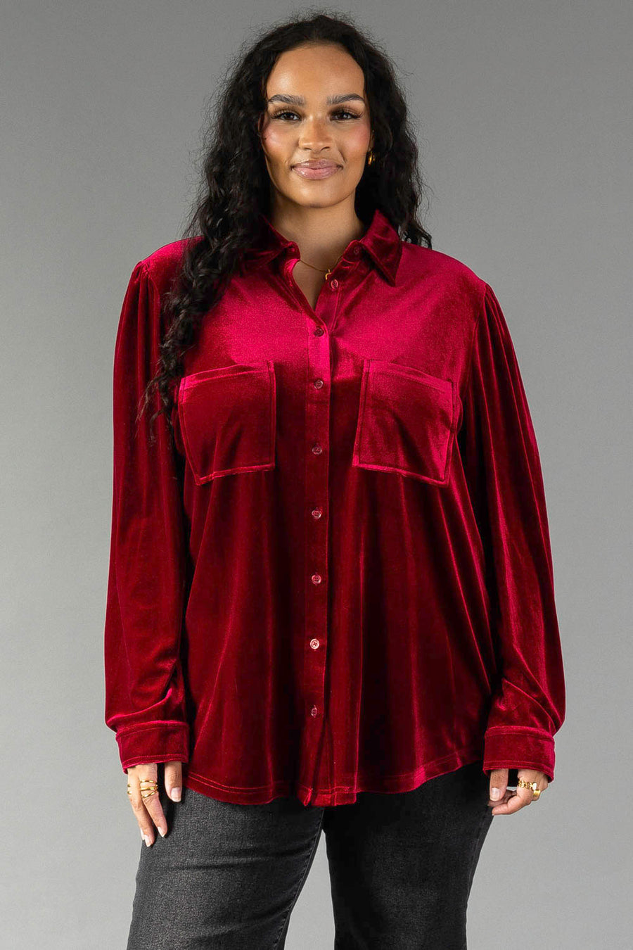 A person wearing a relaxed-fit, burgundy Burgundy Velvet Button Up with two front chest pockets.