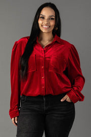 A smiling woman wears a long-sleeved red velvet button-up Panache Apparel Collection Red Velvet Button Up shirt with two front chest pockets and dark jeans.
