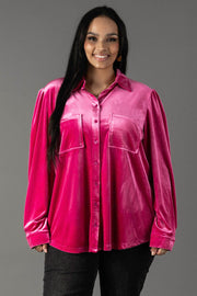 A smiling woman wearing a bright pink Bright Pink Velvet Button Up blouse with two front pockets.