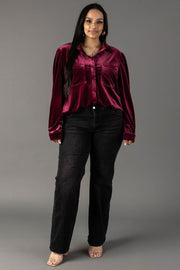 A woman wearing a Maroon Velvet Button Up shirt and black jeans.