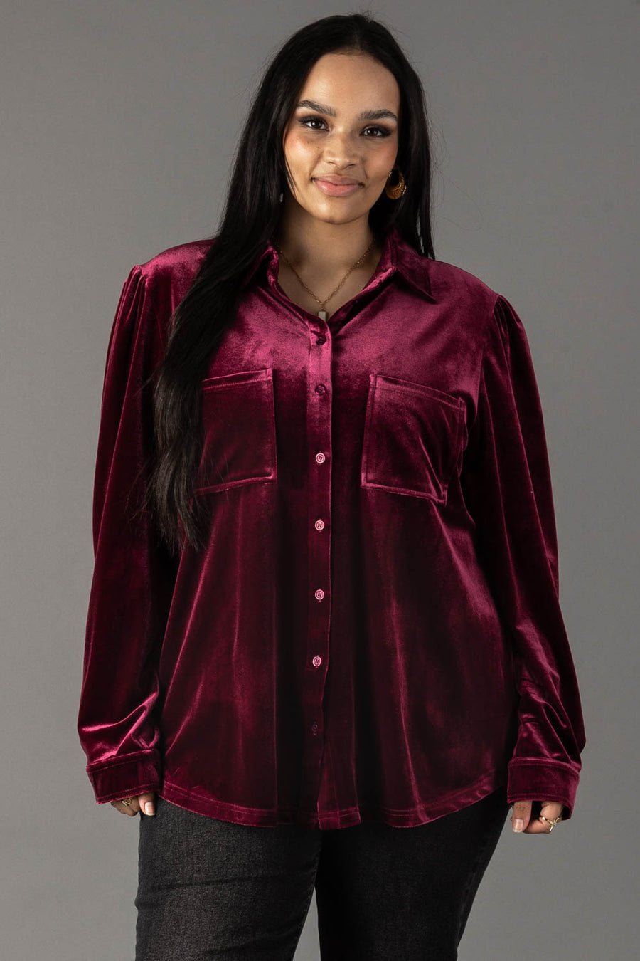 A person wearing a Panache Apparel Collection Maroon Velvet Button Up, a long-sleeved maroon velvet shirt featuring two chest pockets.