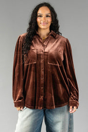 A person wearing a brown velvet Brown Velvet Button Up shirt with two chest pockets and light-wash jeans from Panache Apparel Collection.