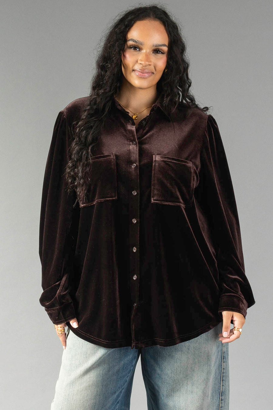 A person wearing an Espresso Brown Velvet Button Up with two front chest pockets and blue jeans.