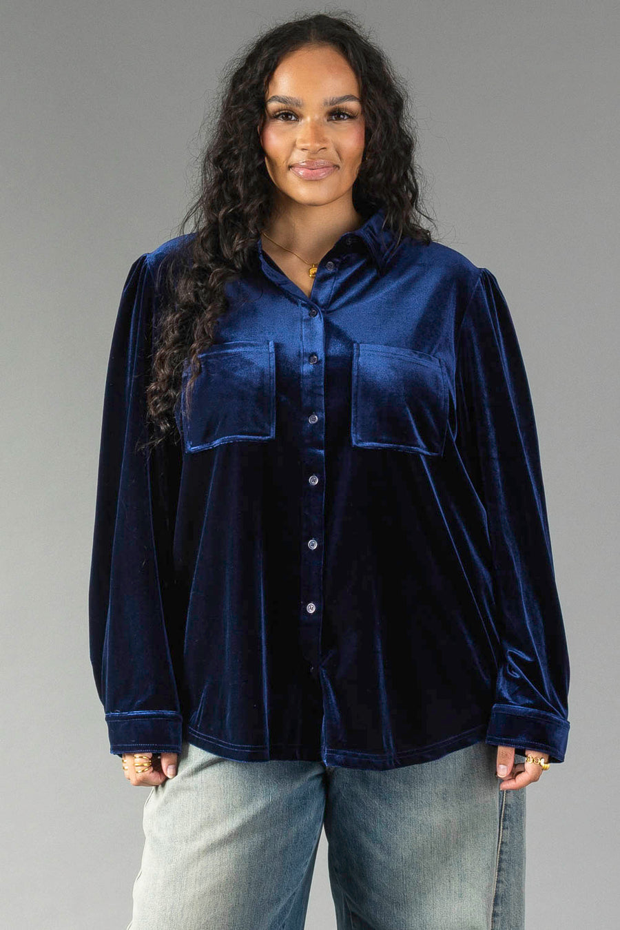 A person wears a relaxed-fit Navy Velvet Button Up by Panache Apparel Collection in navy velvet, featuring two front chest pockets and cuffed sleeves.