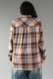 A person with long dark hair, seen from behind, wears the Panache Apparel Collection Dark Brown, Blue & Pink Plaid Button Up and blue jeans, standing against a plain gray background.