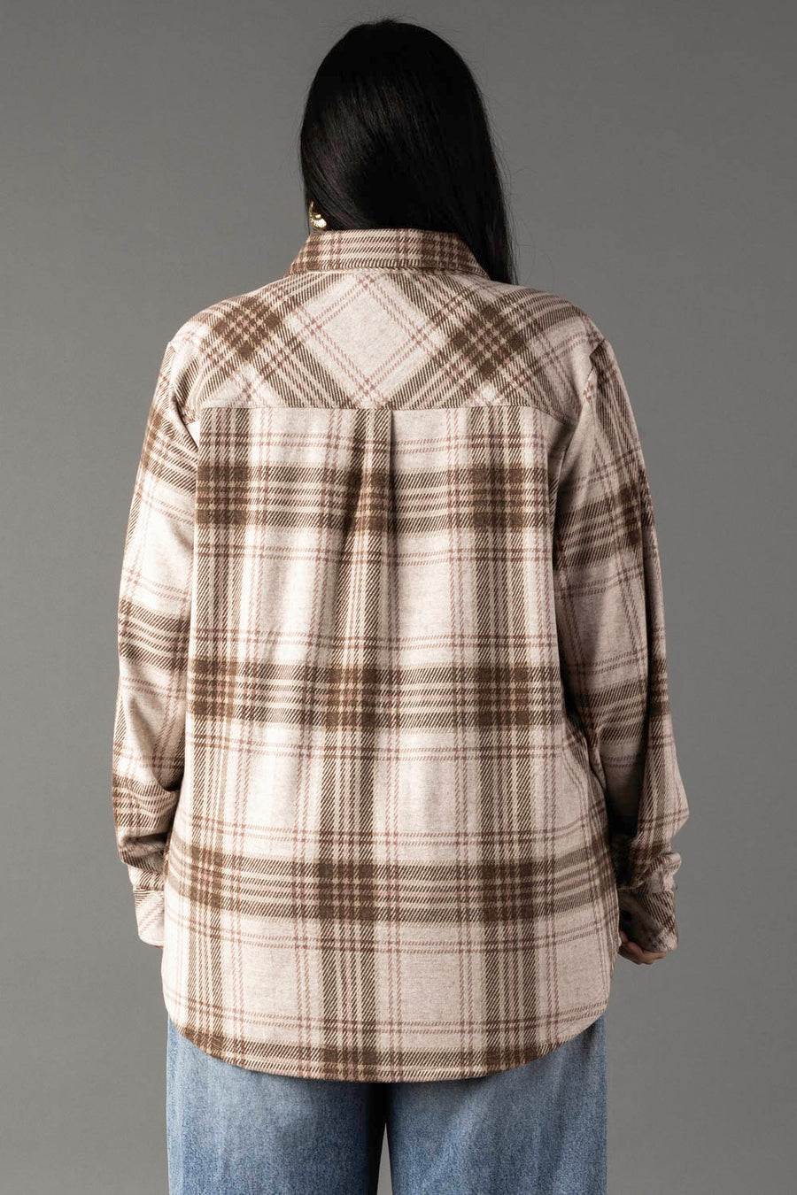 A person with long dark hair is shown from the back, wearing the Panache Apparel Collection Brown, Tan & Rose Plaid Button Up shirt and light blue jeans, standing against a plain gray background.