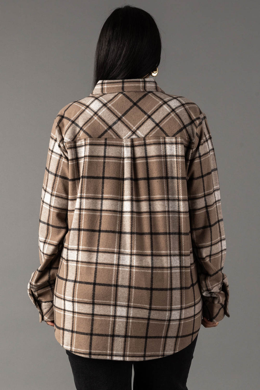 A person with long dark hair is shown from behind, wearing the Panache Apparel Collection Tan, White & Black Plaid Button Up and black pants, standing against a plain gray background.