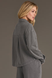 A woman with long blonde hair models the Panache Apparel Collection Gray Cropped Washed Soft Button Up, paired with matching pants, as she stands sideways against a plain background.