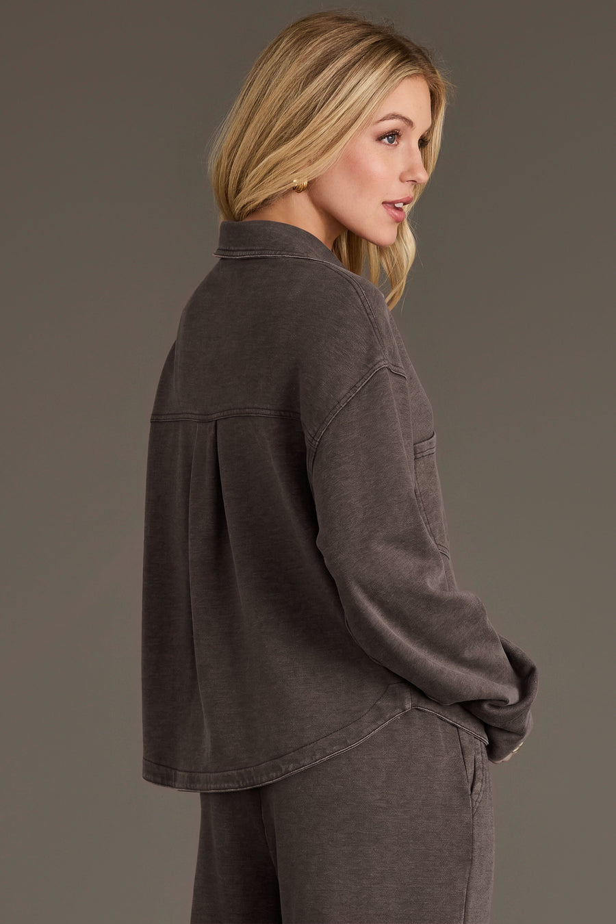A woman wearing a Cocoa Cropped Washed Soft Button Up in cocoa with a box pleat on the back.