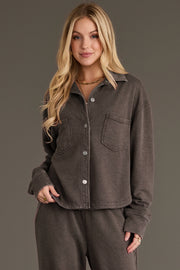 A person wearing a Panache Apparel Collection Cocoa Cropped Washed Soft Button Up, a cocoa-colored cropped shirt with front chest pockets.