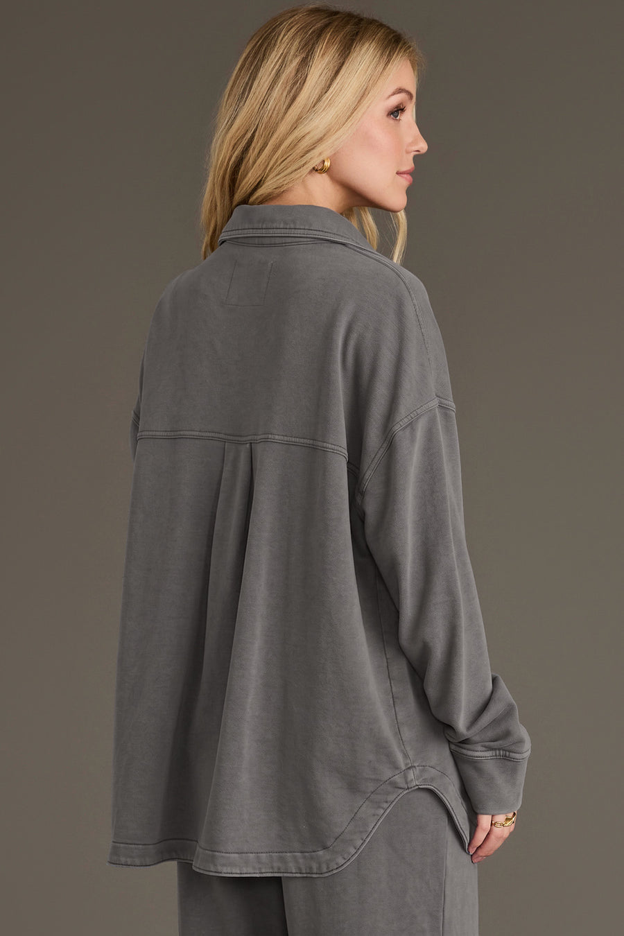 A person wearing a Gray Washed Soft Button Up in gray with a long-sleeved, washed finish and a pleated back detail.
