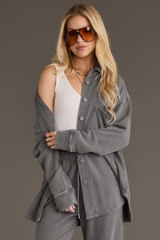 A person wears a Gray Washed Soft Button Up over a white ribbed tank top and matching gray sweatpants, finished with large tinted sunglasses.