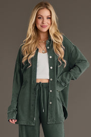 A woman wears a pine green Pine Green Washed Soft Button Up over a white ribbed crop top and matching green drawstring pants.