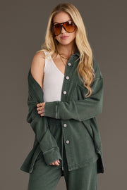 A woman wearing a Pine Green Washed Soft Button Up over a white ribbed tank top and matching green bottoms.