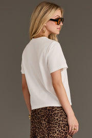 A woman wearing sunglasses and the Panache Apparel Collection’s Howdy Western Graphic Tee stands turned slightly to the side against a plain background.