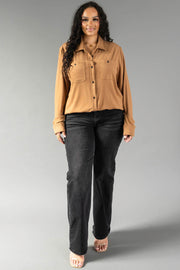 A person wearing a Dark Tan Super Soft Button Up shirt with two chest pockets and black straight-leg jeans.