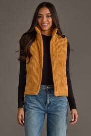 A woman models the Panache Apparel Collection Mustard Corduroy Vest over a long-sleeve black top and blue jeans, smiling as she stands against a plain gray background.