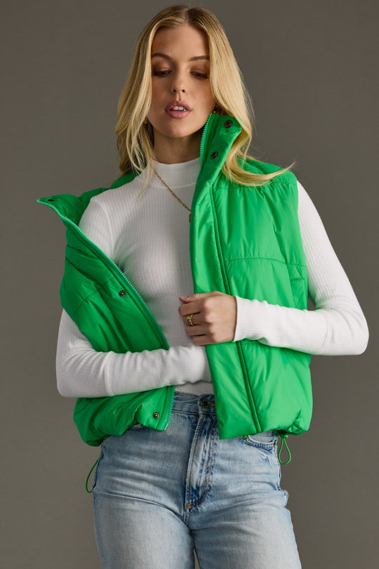 Front view of Bright Green World Traveler Vest styled open, showing the high collar and padded design.