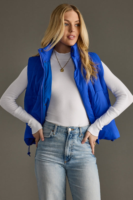 Front view of Royal Blue Vest styled open, featuring padded quilting, high collar, and sleeveless silhouette.