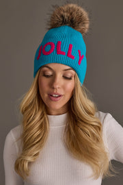 A Blue Jolly Knit Pom Hat featuring the word JOLLY in pink letters, a fleece lining, and a faux fur pom-pom on top.