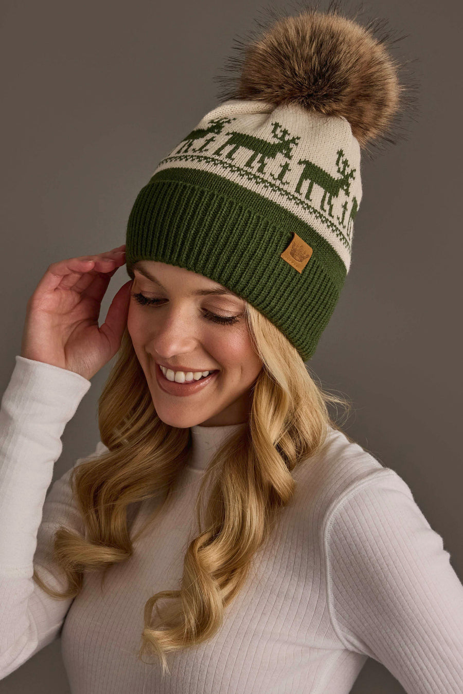 Panache Apparel Collection Olive & Beige Deer Patterned Pom Hat in olive and beige, featuring a deer pattern, fleece lining, and a large faux fur pom-pom.