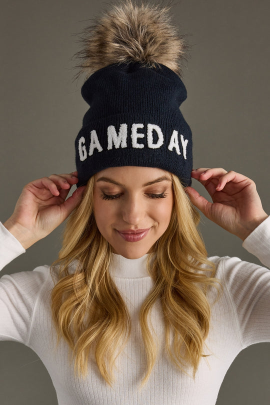 Woman wearing Panache Apparel’s navy and white Game Day pom hat.