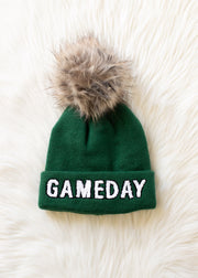 Flat lay of Panache Apparel’s green and white Game Day pom hat.