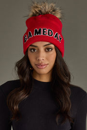 Close-up of woman wearing Panache Apparel’s red Game Day pom hat with black lettering.