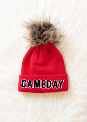 Flat lay of Panache Apparel’s red and black Game Day pom hat.