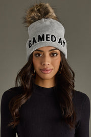 Woman with long dark hair wearing Panache Apparel’s gray and black Game Day pom hat.