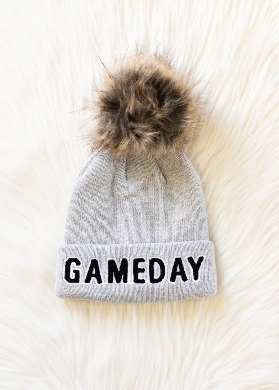 Flat lay of Panache Apparel’s gray and black Game Day pom hat.