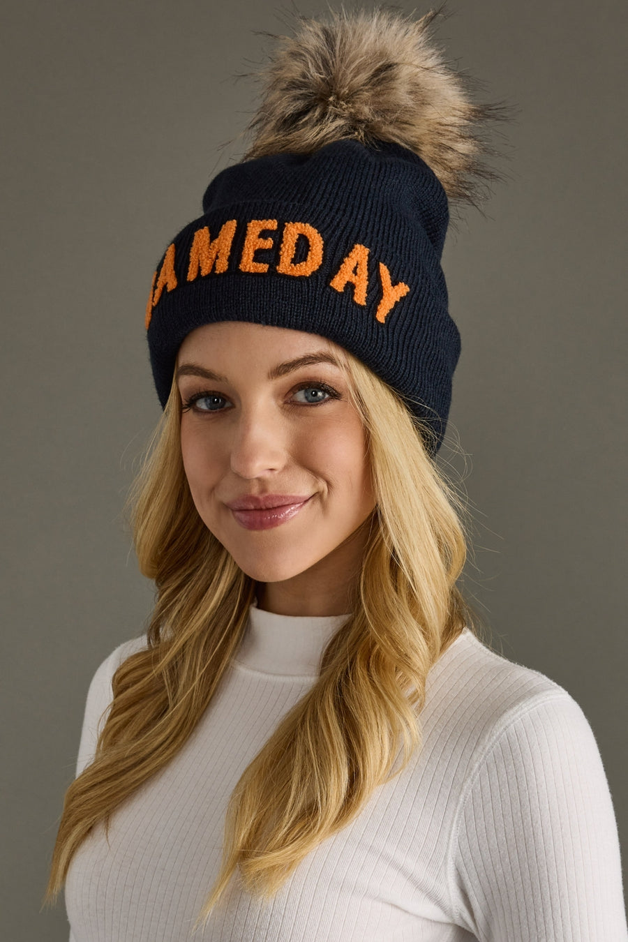 Three-quarter view of Panache Apparel’s navy and orange Game Day winter hat styled on a woman.