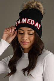 Woman styling Panache Apparel’s black Game Day winter hat featuring contrast white and red text with a folded cuff.