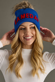 Front portrait of a model styling Panache Apparel’s royal blue Game Day knit hat with red text and a ribbed cuff.