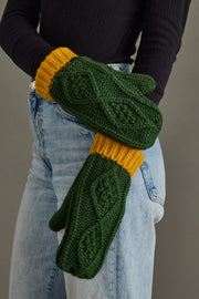 Close-up of woman wearing Panache Apparel’s green and gold cable knit mittens.