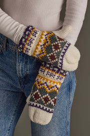 A person wearing blue jeans and a white ribbed shirt displays the Ivory, Purple & Gold Patterned Mittens from Panache Apparel Collection.